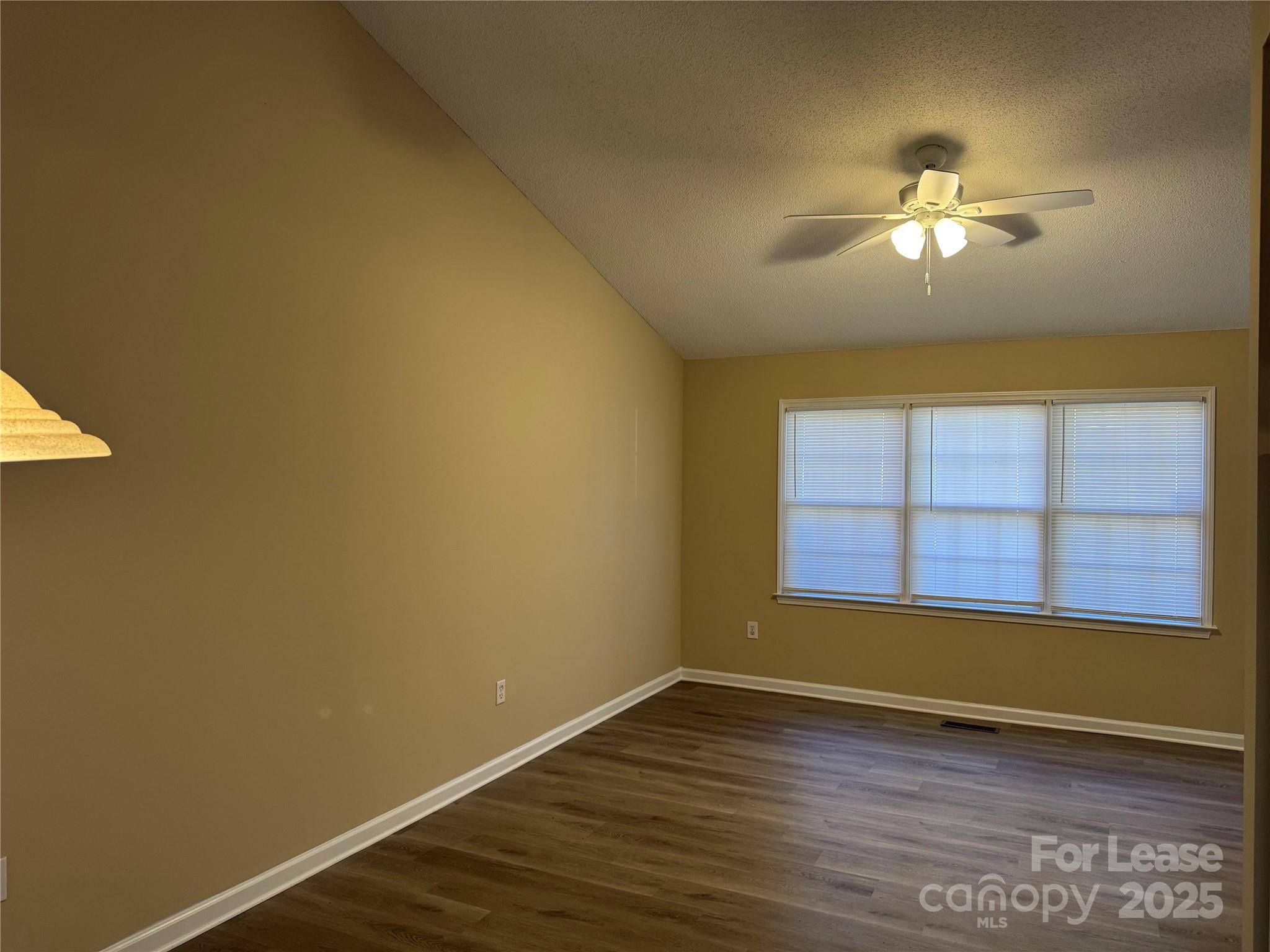 1424 Ridgewood Drive Concord, NC 28027 - Photo 9 of 14 a view of empty room with wooden floor and fan