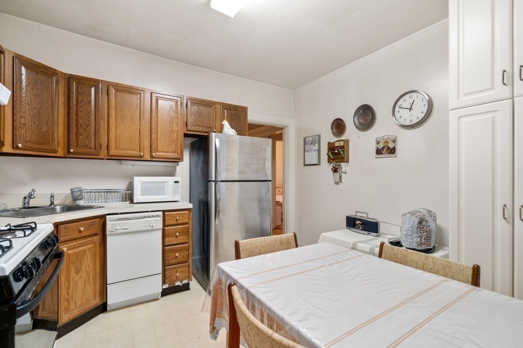 6 Colborne Road, Unit 1 Boston, MA 02135 - Photo 3 of 11 a kitchen with a refrigerator a stove top oven a clock and a refrigerator