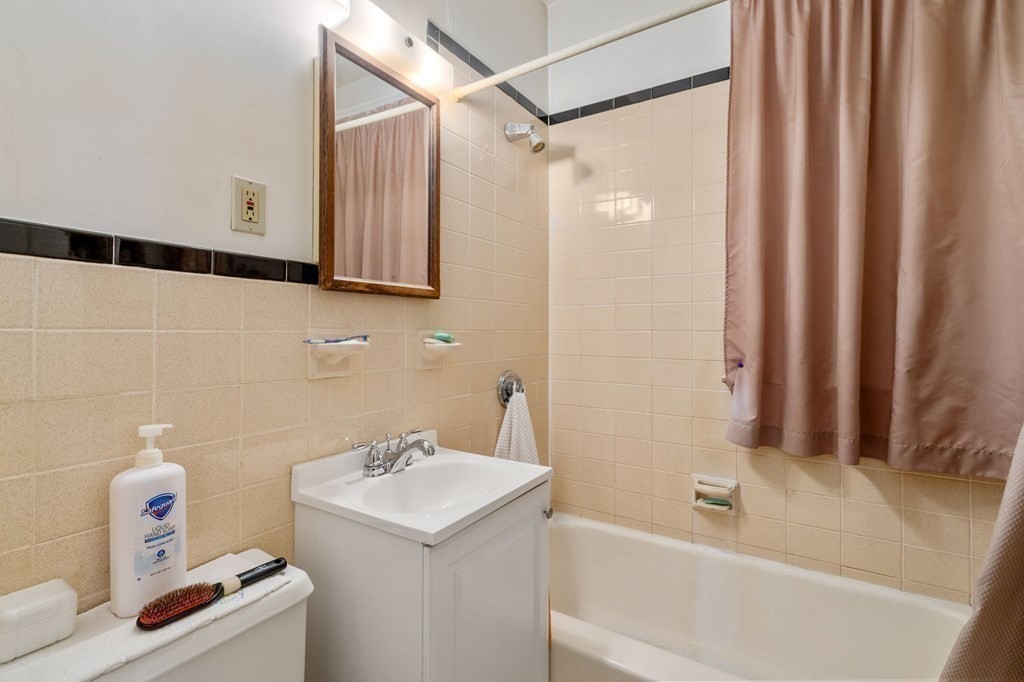 6 Colborne Road, Unit 1 Boston, MA 02135 - Photo 8 of 11 a bathroom with a sink a bath tub and a shower curtain