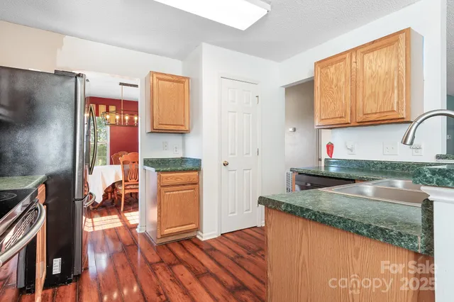 a kitchen with granite countertop wooden floors and stainless steel appliances
