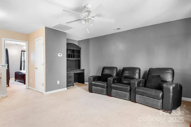 a living room with furniture and a ceiling fan
