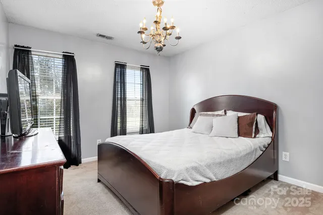 a bedroom with a large bed and a chandelier