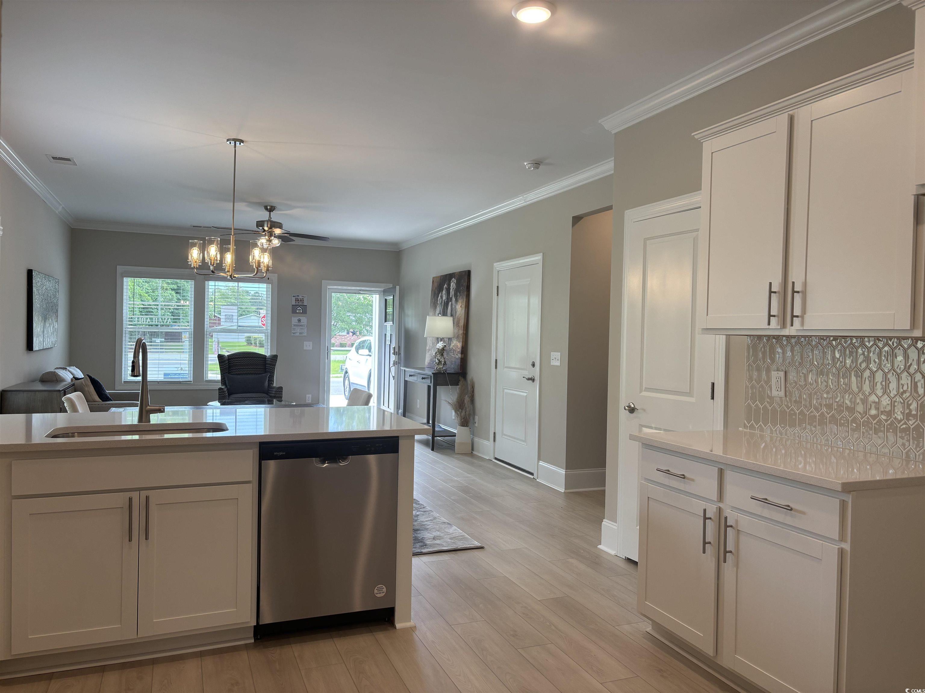 3125 Tiger Tail Road Conway, SC 29526 - Photo 36 of 37 Kitchen featuring stainless steel dishwasher, a sink, light countertops, open floor plan, and tasteful backsplash