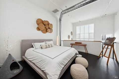 a bedroom with a bed and a chair in it