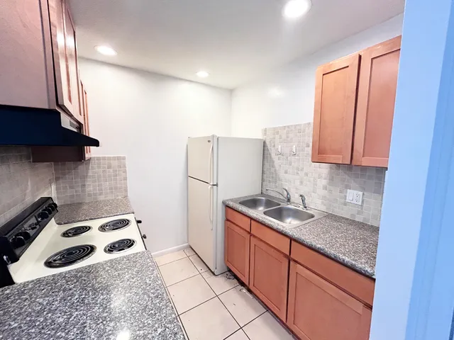 a kitchen with stainless steel appliances granite countertop a sink stove and refrigerator