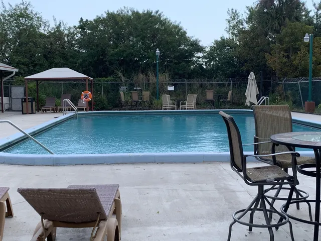 a view of a swimming pool with a table and chairs under an umbrella