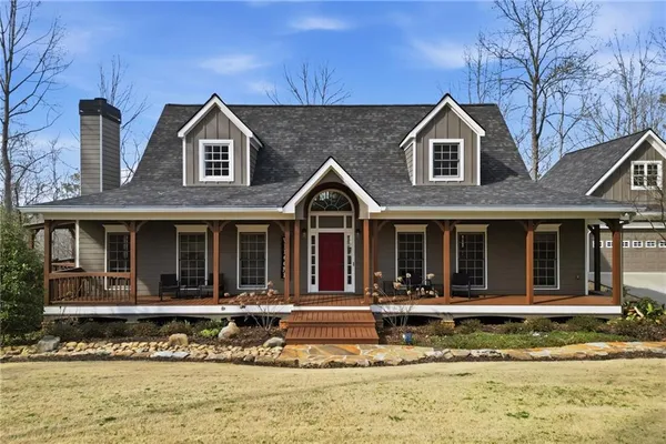 a view of a brick house with large windows and a large tree