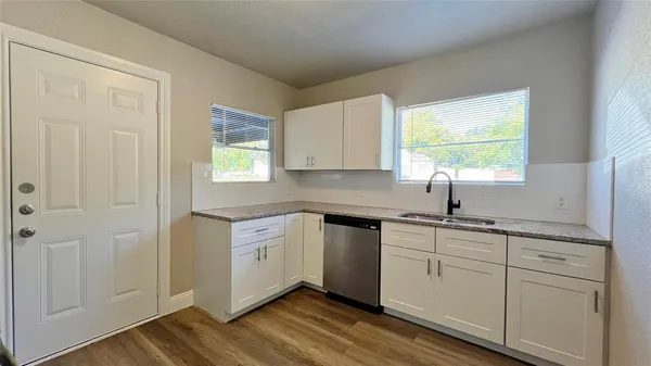 a kitchen with white cabinets and a window