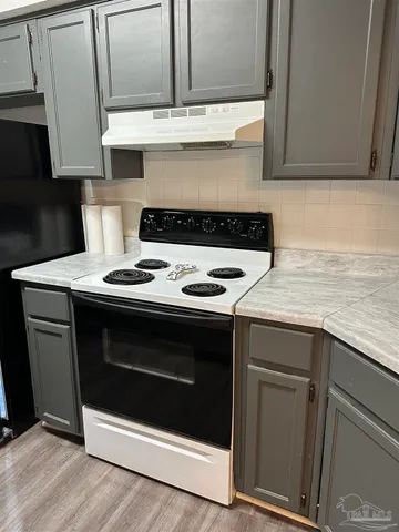 a stove top oven sitting inside of a kitchen