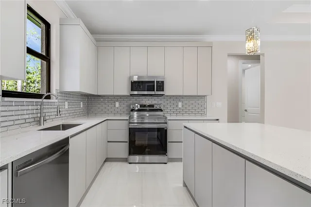a kitchen with stainless steel appliances granite countertop a sink stove and microwave