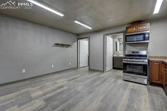 a kitchen with granite countertop a stove top oven sink and cabinets