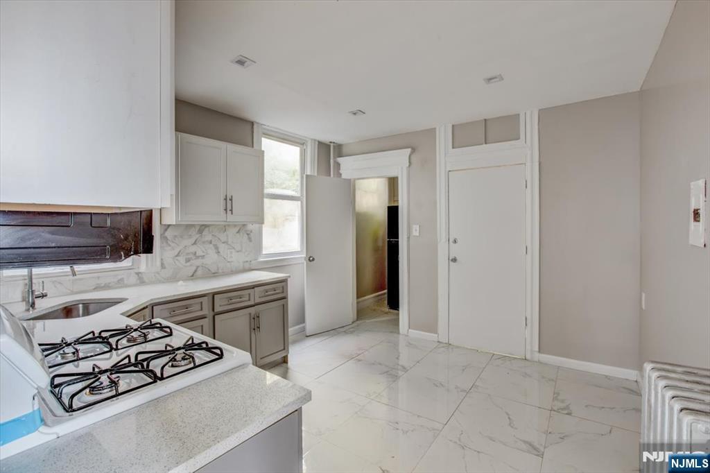 70 South 9th Street Newark, NJ 07107 - Photo 11 of 29 a kitchen with stainless steel appliances granite countertop a sink stove and refrigerator