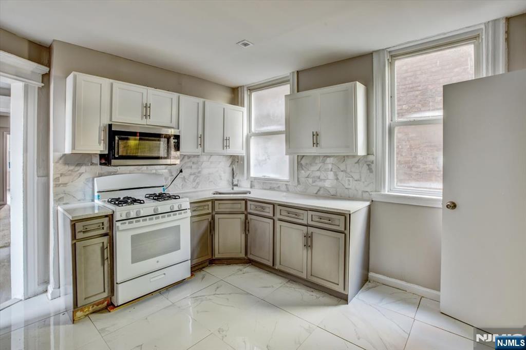 70 South 9th Street Newark, NJ 07107 - Photo 12 of 29 a kitchen with cabinets stainless steel appliances and a window
