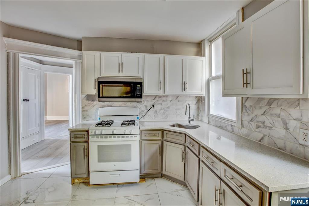 70 South 9th Street Newark, NJ 07107 - Photo 13 of 29 a kitchen with white cabinets stainless steel appliances and sink