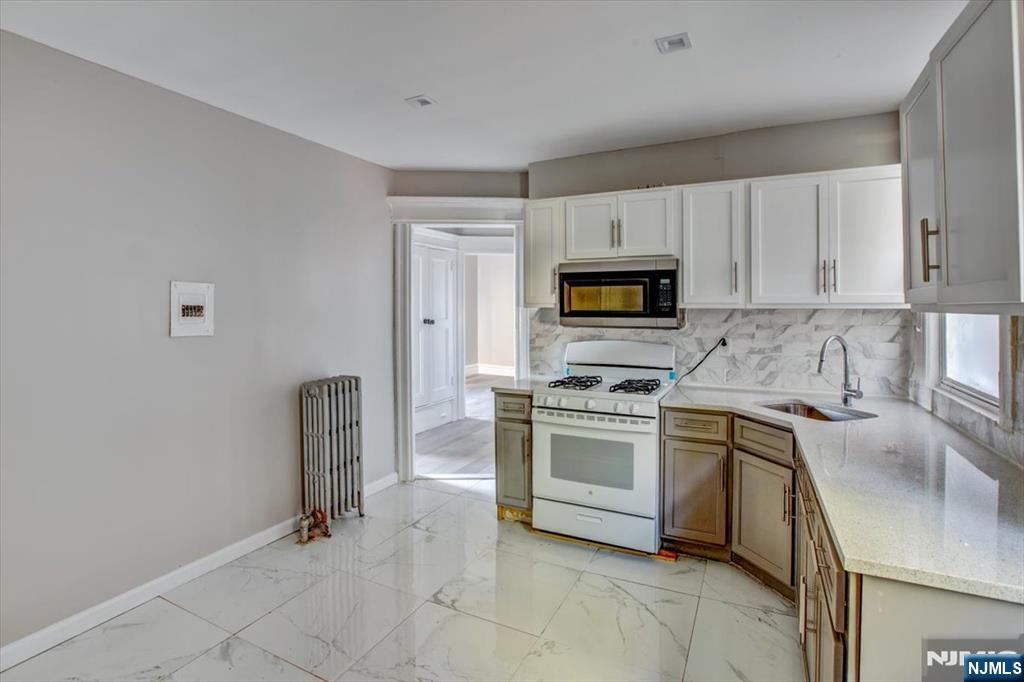 70 South 9th Street Newark, NJ 07107 - Photo 14 of 29 a kitchen with granite countertop a sink a stove top oven and appliances