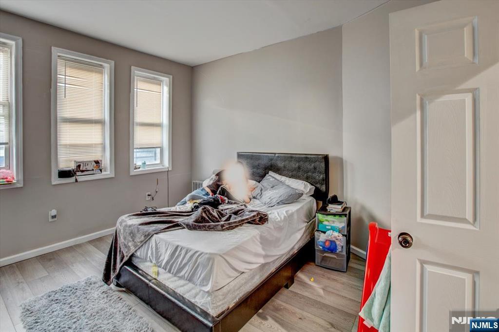 70 South 9th Street Newark, NJ 07107 - Photo 26 of 29 a bed sitting in a bedroom next to a window
