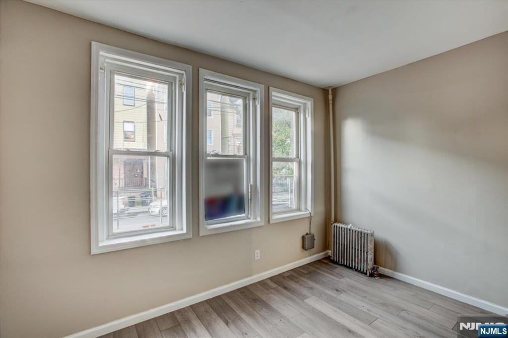 70 South 9th Street Newark, NJ 07107 - Photo 10 of 29 a view of an empty room with a window and wooden floor