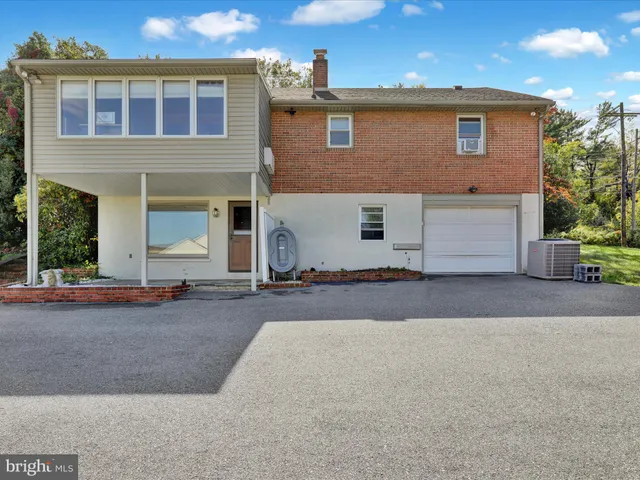 a view of a house with backyard and a tree