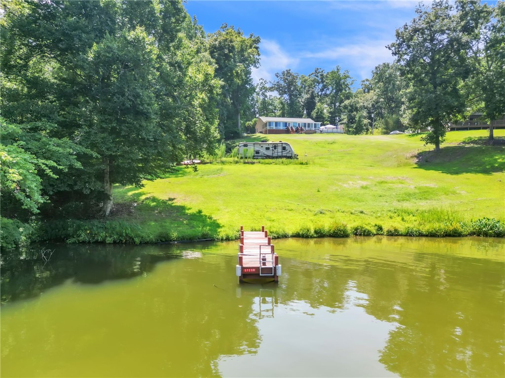 48 Tierra Drive Waterloo, SC 29384 - Photo 2 of 42 A private floating dock extends over the water below a sprawling grassy lakeside lawn.