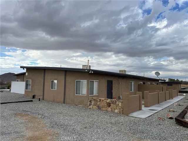 a backyard of a house with barbeque oven and garage