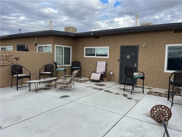 a view of a patio with table and chairs and potted plants