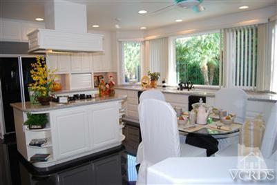 Undisclosed Address Calabasas, CA 91302 - Photo 5 of 10 a kitchen with a table chairs stove and cabinets