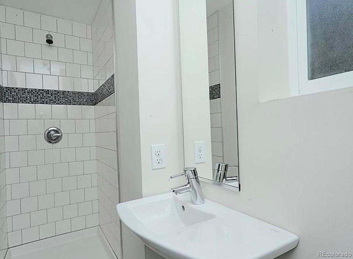 3217 Lawrence Street Denver, CO 80205 - Photo 12 of 13 a bathroom with a sink and shower