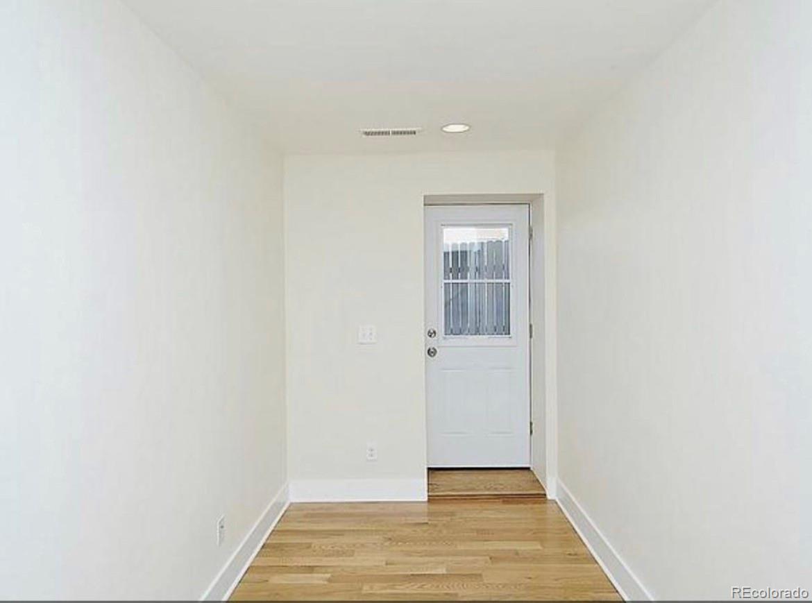 3217 Lawrence Street Denver, CO 80205 - Photo 13 of 13 a view of a hallway with wooden floor