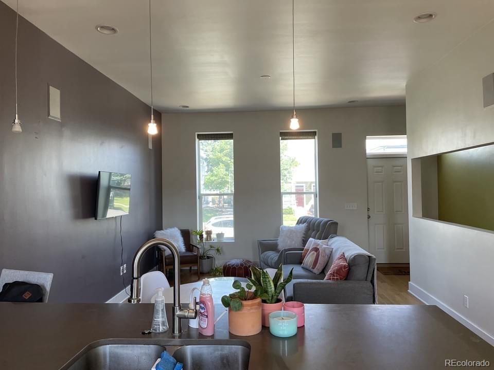 3217 Lawrence Street Denver, CO 80205 - Photo 7 of 13 a living room with furniture and a potted plant