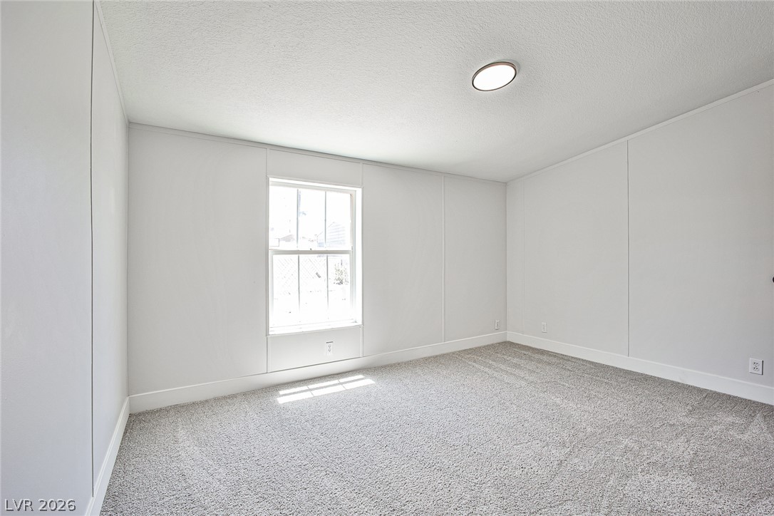 273 Aztec Lane Henderson, NV 89015 - Photo 24 of 28 A well-lit bedroom featuring a light gray carpet and simple, clean lines.