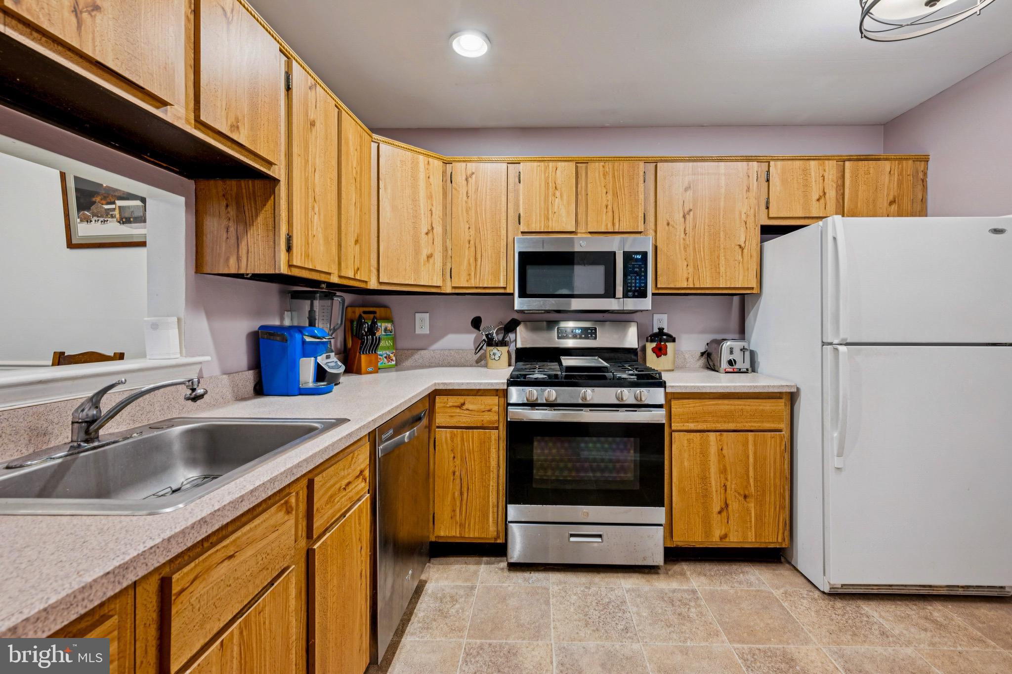 112 Village Lane Mount Laurel, NJ 08054 - Photo 9 of 17 a kitchen with stainless steel appliances granite countertop a refrigerator stove microwave sink and cabinets