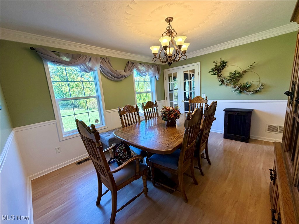 7374 Virginia Road Atwater, OH 44201 - Photo 9 of 49 Dining room with ornamental molding, french doors, light wood-style floors, and a chandelier