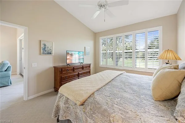 a bedroom with a bed a couch and a large window