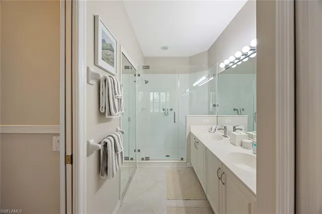 a spacious bathroom with a double vanity sink a shower and a mirror