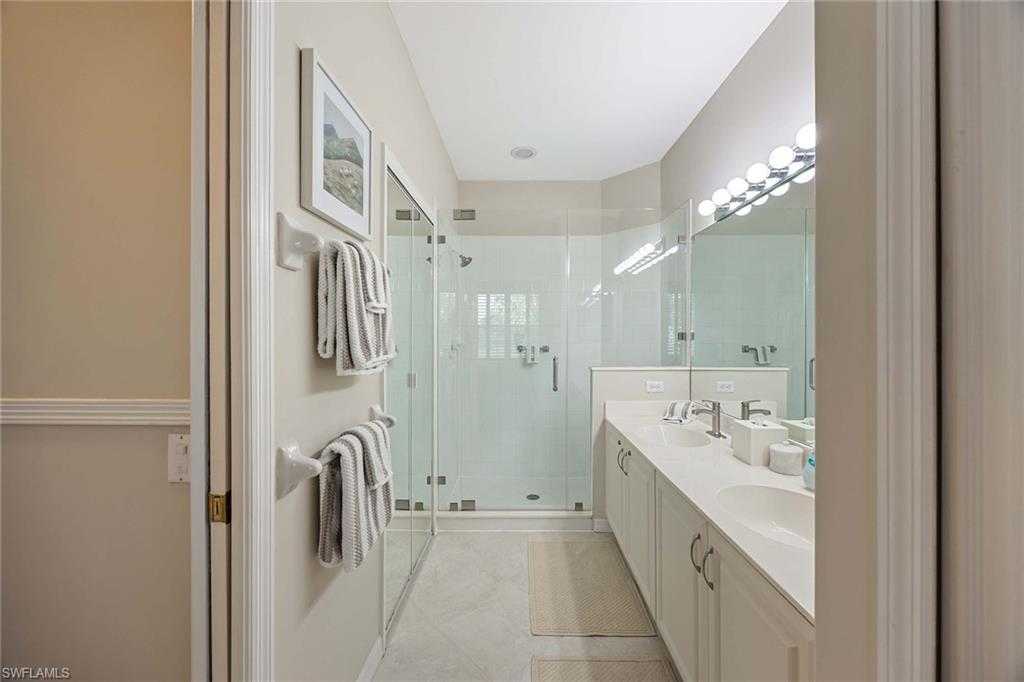 9030 Spring Run Boulevard, Unit 508 Estero, FL 34135 - Photo 16 of 41 a spacious bathroom with a double vanity sink a shower and a mirror