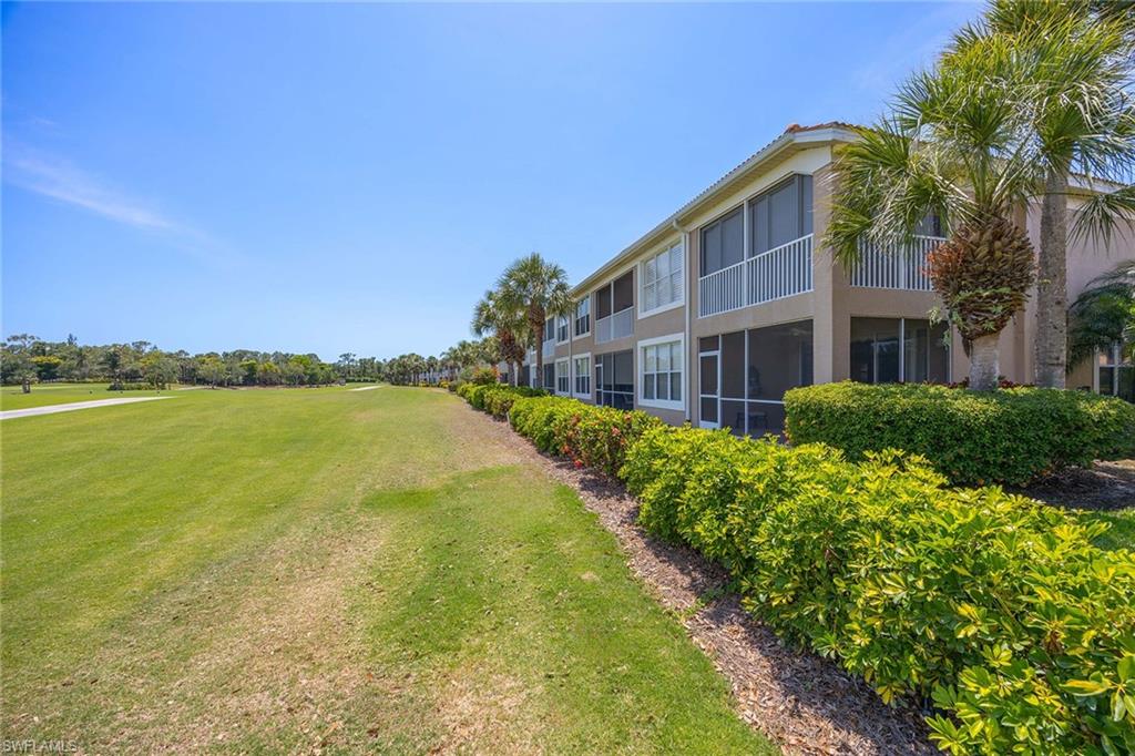 9030 Spring Run Boulevard, Unit 508 Estero, FL 34135 - Photo 25 of 41 a front view of a house with a garden and lake view