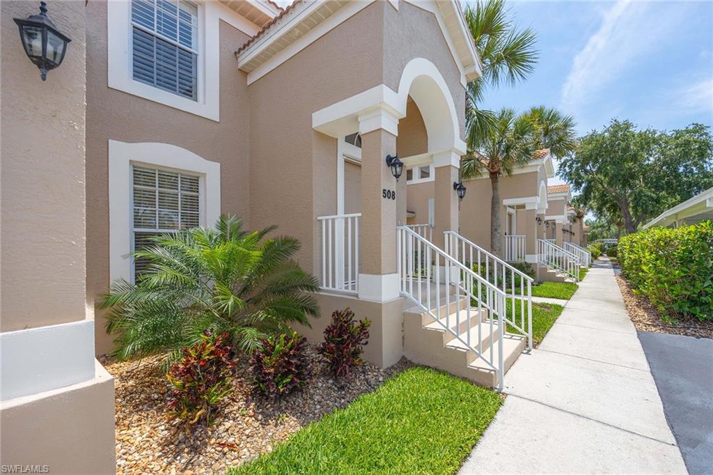 9030 Spring Run Boulevard, Unit 508 Estero, FL 34135 - Photo 3 of 41 a view of a house with a large windows and flower plants