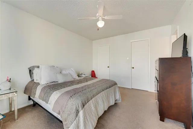 a bedroom with a bed and a refrigerator