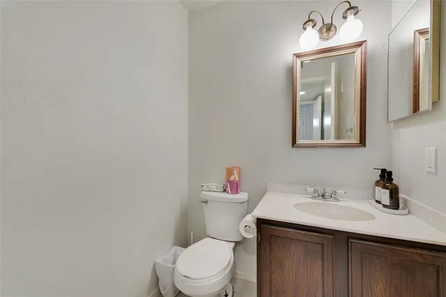 a bathroom with a sink vanity mirror and toilet