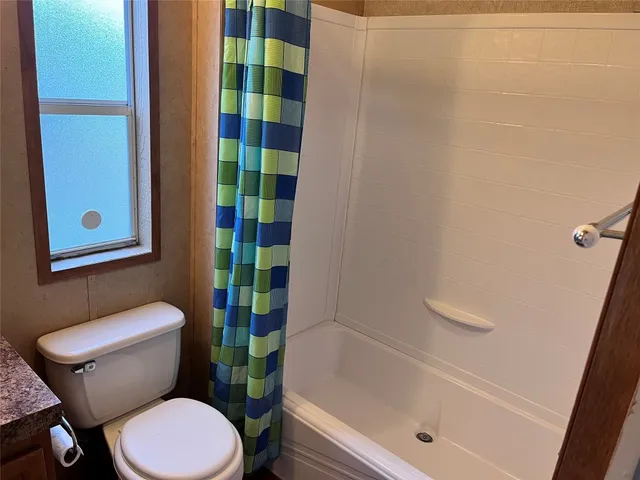 a white toilet sitting next to a bath tub