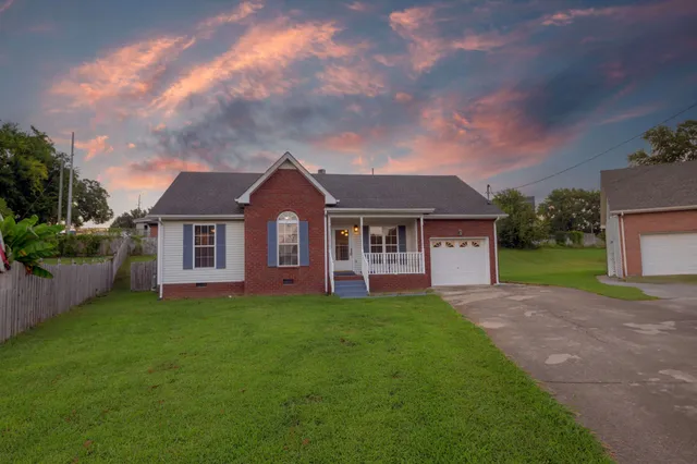 a front view of a house with a garden and yard