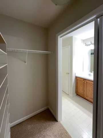 an empty room with wooden floor chandelier fan and closet area
