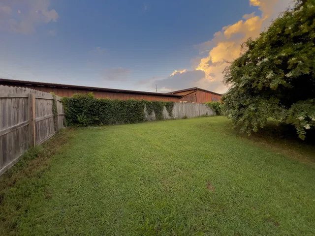 a view of a big yard with large trees