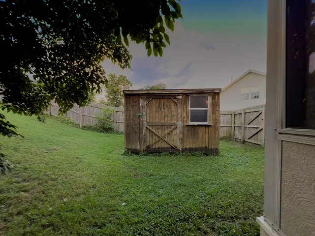 a backyard of a house with barbeque oven and palm tree