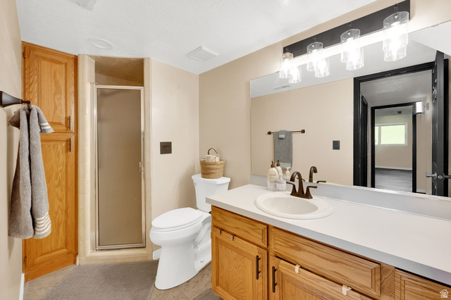 5057 South Ridgedale Drive Ogden, UT 84403 - Photo 47 of 69 Bathroom featuring a single vanity with wood cabinetry, a white countertop, and a bronze faucet