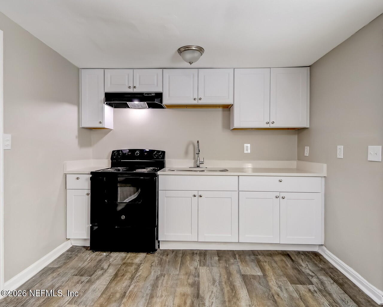 2140 Jayson Avenue Jacksonville, FL 32208 - Photo 12 of 34 a kitchen with granite countertop white cabinets and black appliances