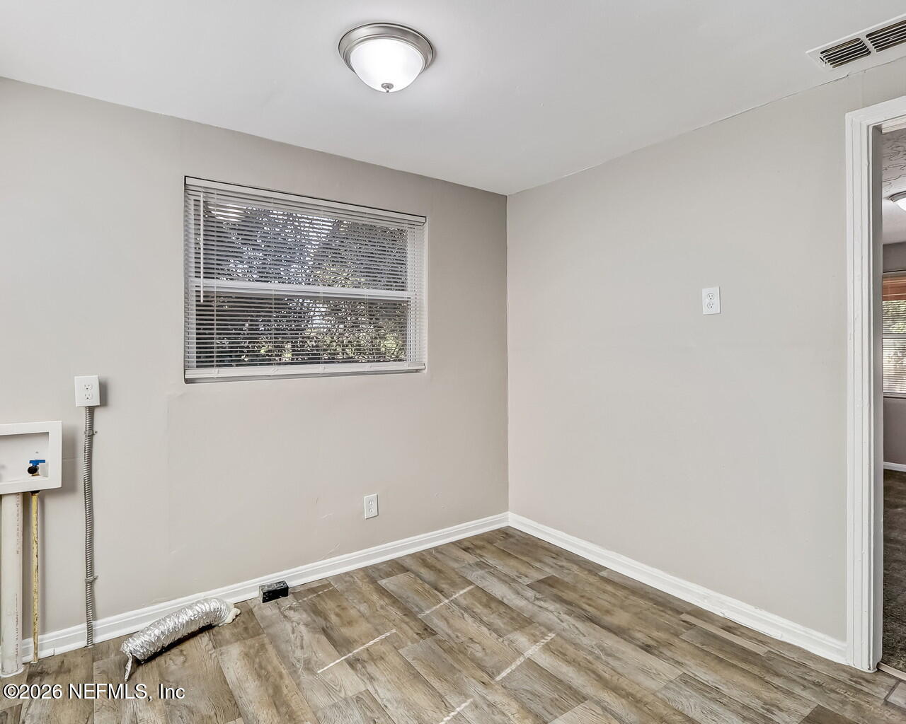 2140 Jayson Avenue Jacksonville, FL 32208 - Photo 15 of 34 a view of an empty room with wooden floor and a window