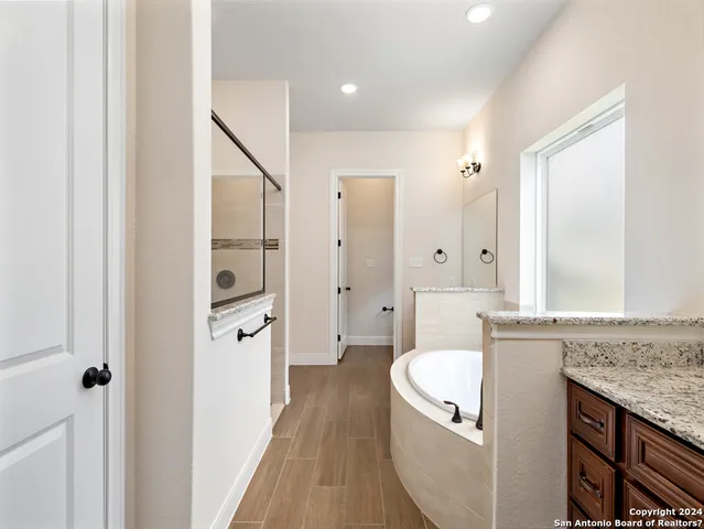 a spacious bathroom with a granite countertop sink and a mirror