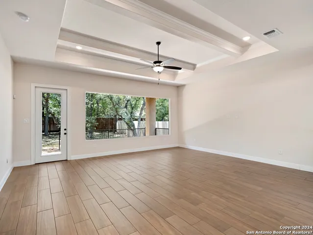 a view of an empty room with window wooden floor and front door