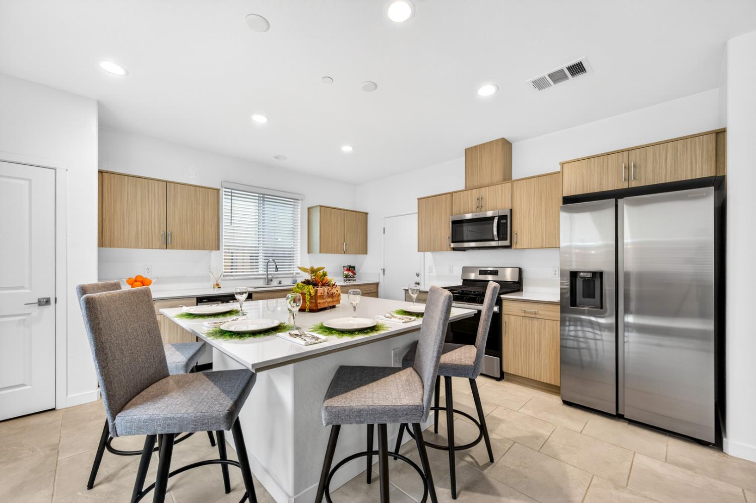 317 Talus Way South Madera, CA 93636 - Photo 7 of 61 a kitchen with stainless steel appliances kitchen island granite countertop a dining table chairs refrigerator and microwave